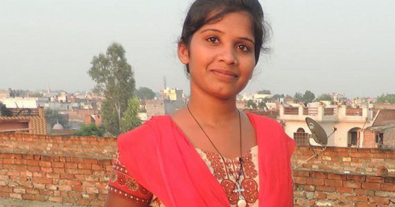 picture of Geethu, the daughter of a Hindu priest, with her Bible