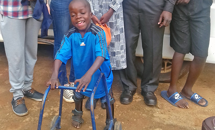 4-year-old Richard smiling with walker