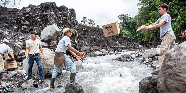 Picture of relif team throwing emergency supplies across river in Guatemala