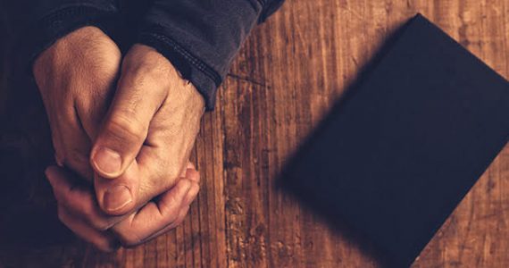 Picture of praying hands and Bible