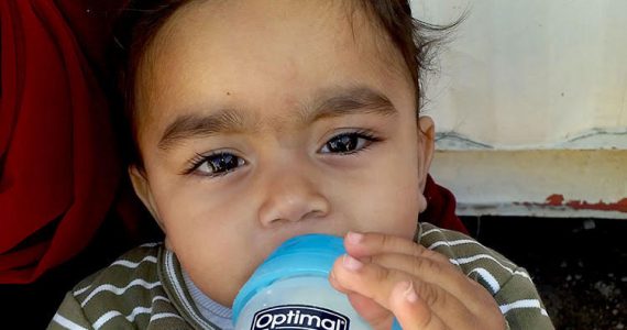 Picture of Syrian refugee baby drinking formula