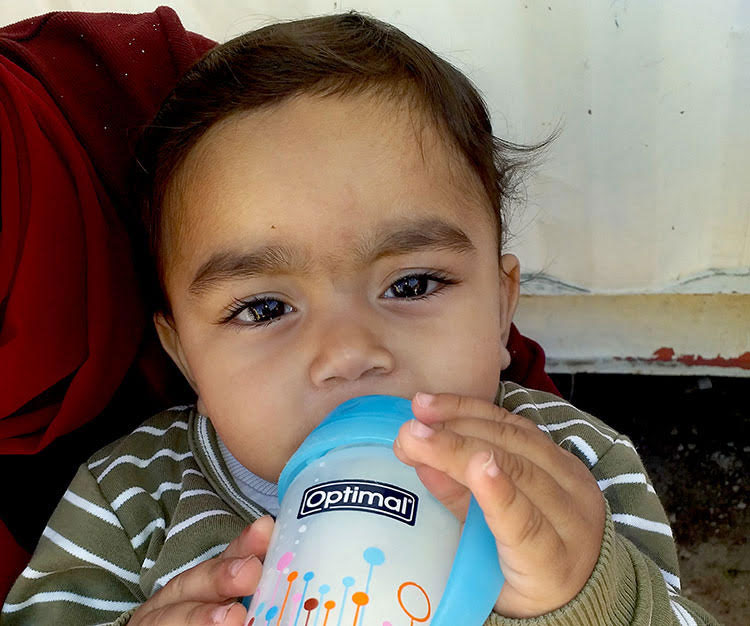Picture of Syrian refugee baby drinking formula