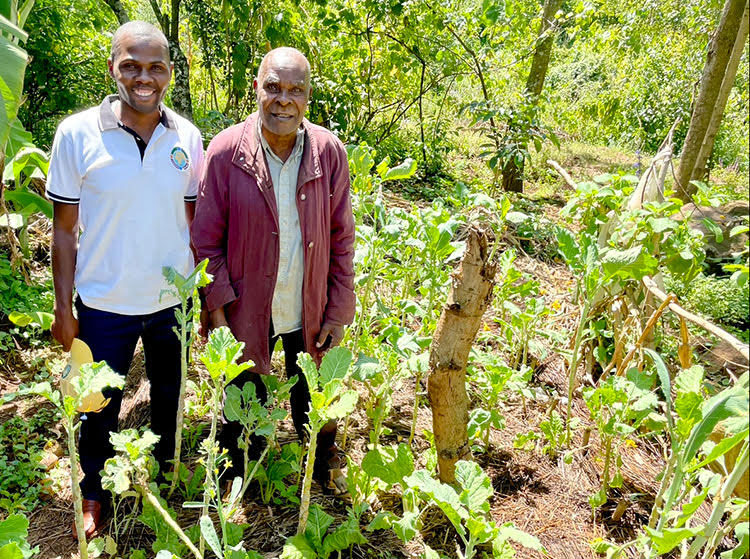 Picture of Griffin with a farmer in Kenya