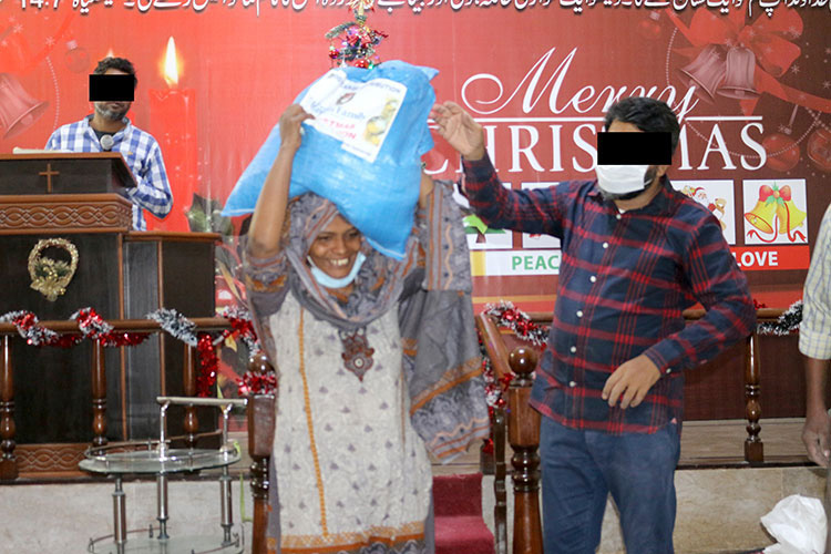 Picture of a believer in Pakistan receiving relief goods