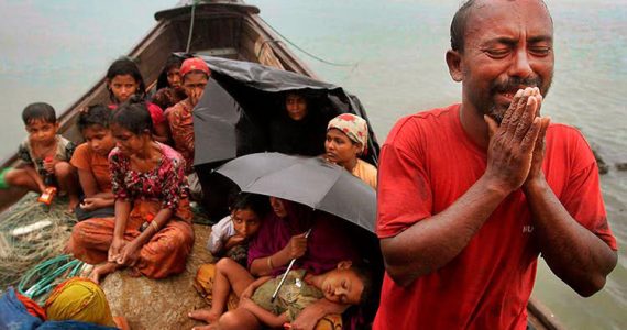 refugee man weeping with family in boat