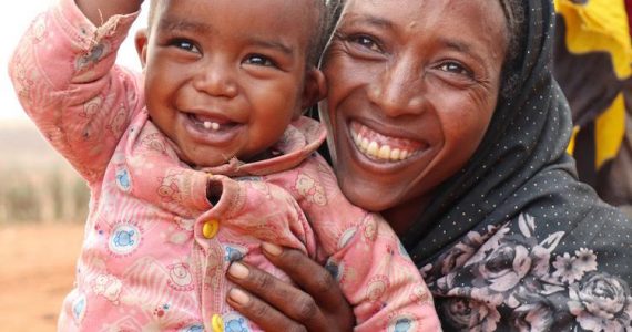 woman from Ethiopia's Borena tribe holding child