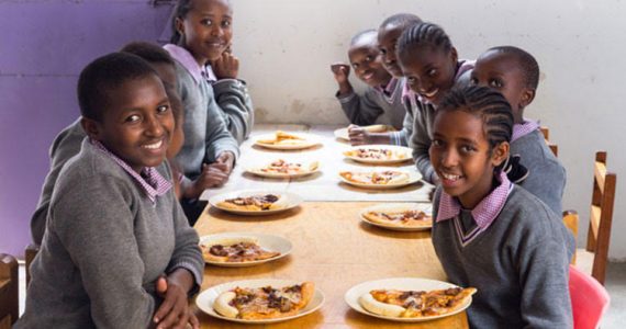Picture of girls in Kenya enjoying pizza