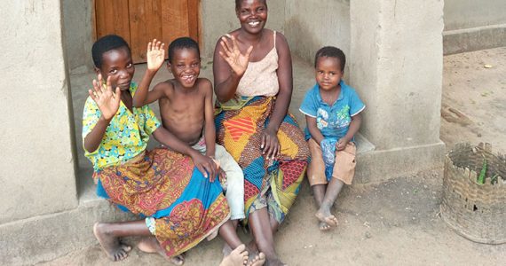 Picture of family in Malawi with house provided by Disaster Relief Ministry
