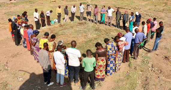 Picture of farmers praying over farmland