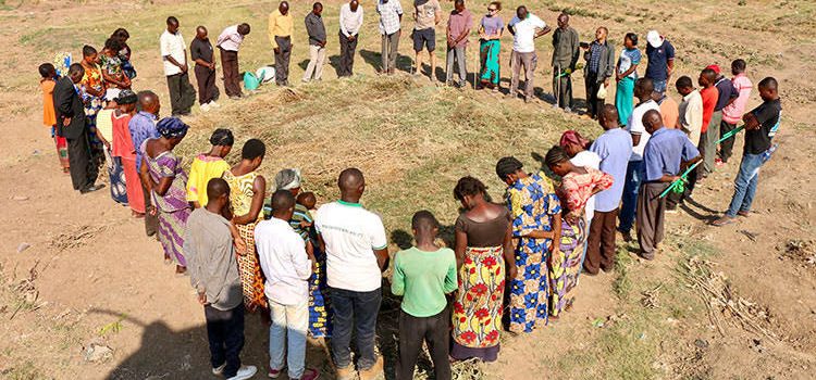 Picture of farmers praying over farmland