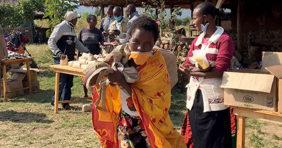 Picture of a mom in Kenya taking food home
