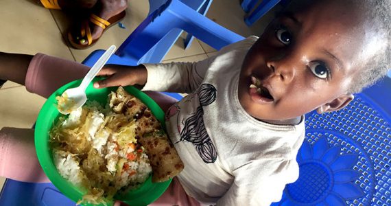 Image of child in Kibera, Kenya receiving food